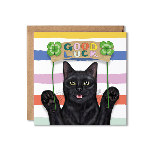 Greeting card with a black cat holding a 'Good Luck' sign with clovers on a striped background.