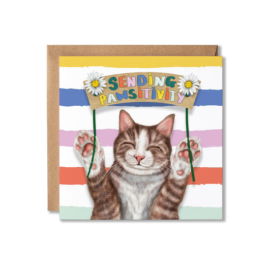 A square greeting card with a brown envelope behind it, featuring an illustrated tabby-and-white cat holding a sign that reads “SENDING PAWSITIVITY.” The card has colourful horizontal stripes and daisy decorations, displayed on a clean white background.