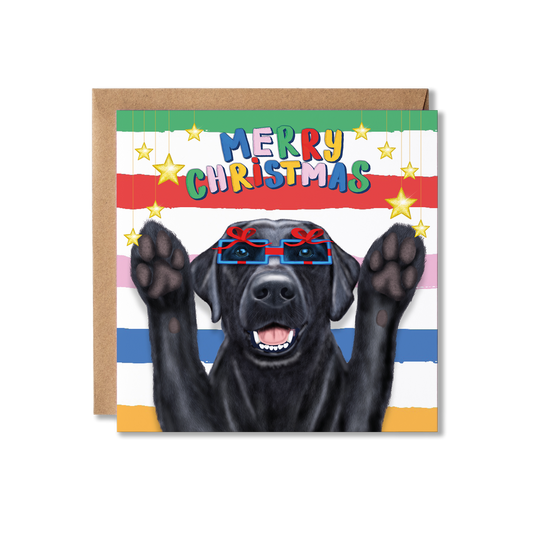 A square Christmas greeting card featuring a black dog wearing present shaped glasses and raising its paws, with the text 'MERRY CHRISTMAS' in colorful letters. The card has a striped background and is shown with a brown kraft envelope.