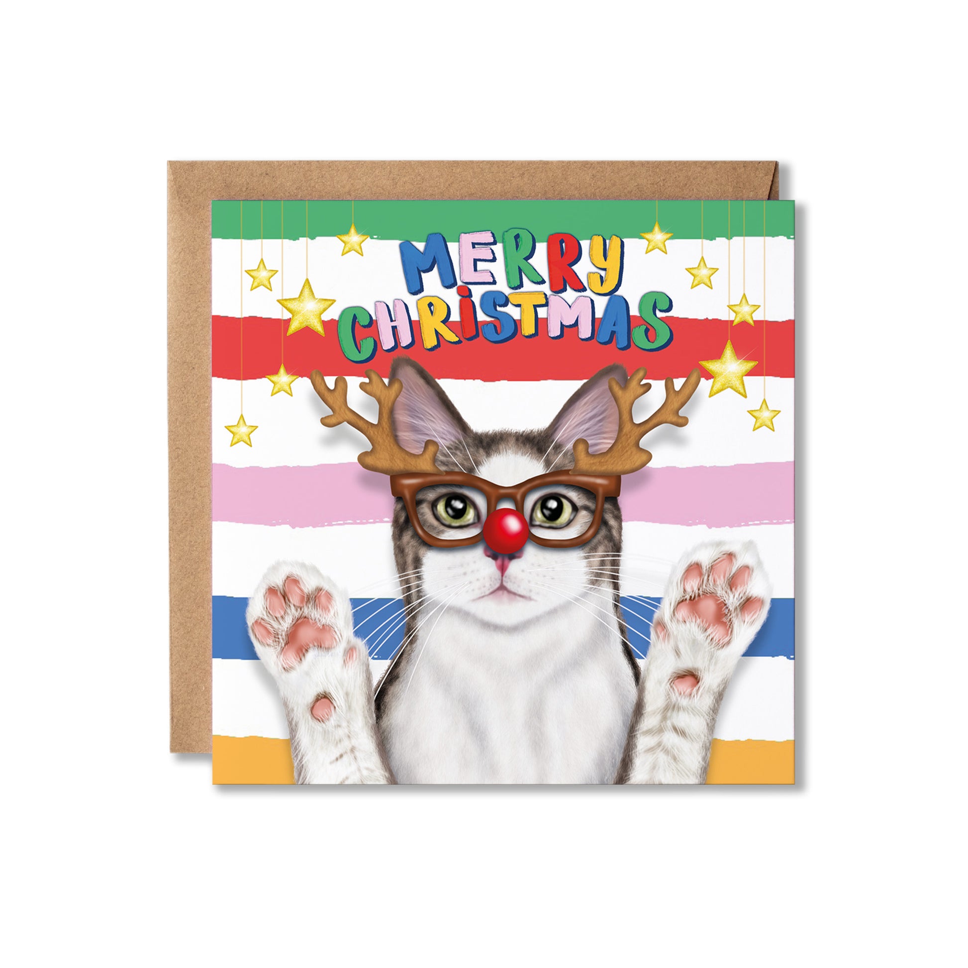 A square Christmas greeting card with a brown kraft envelope behind it. The card features a white and grey cat wearing brown reindeer antlers, round glasses, a red nose, and raised paws against a striped multicolor background with the text 'MERRY CHRISTMAS' and gold stars.