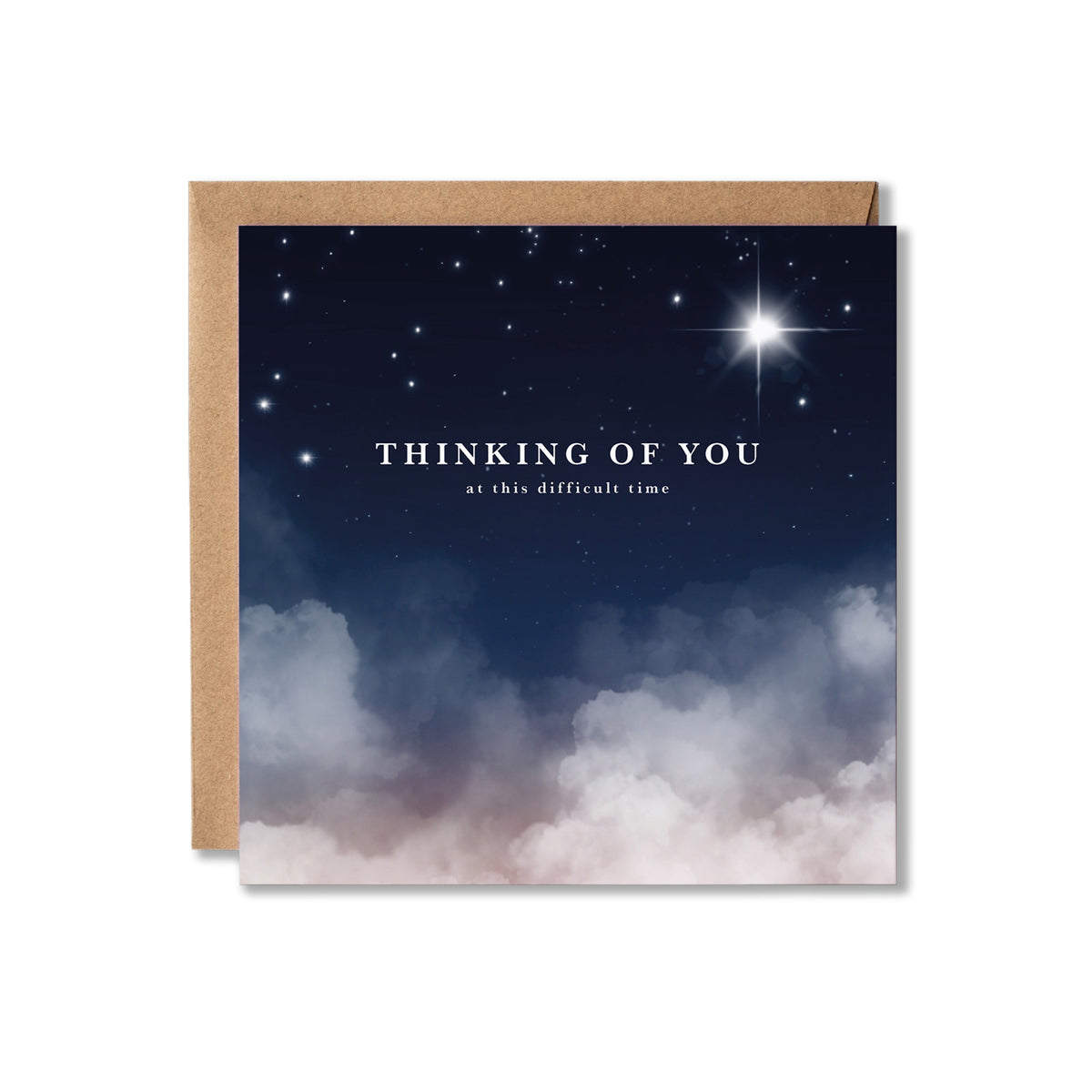 A square greeting card with a kraft paper envelope, featuring a night sky design with stars, a bright starburst, and soft clouds at the bottom. The card reads 'THINKING OF YOU at this difficult time'.