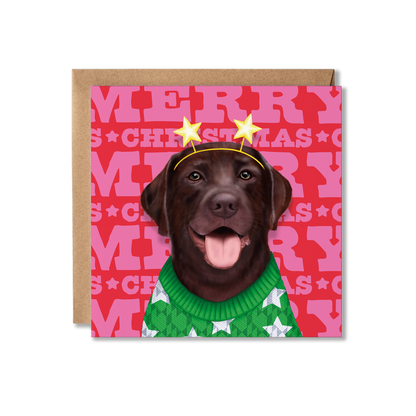A chocolate Labrador in a green Christmas jumper with a star headband and Merry Christmas background