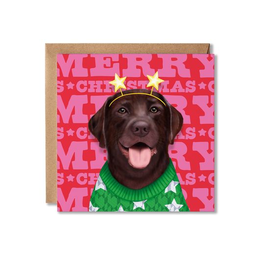 A chocolate Labrador in a green Christmas jumper with a star headband and Merry Christmas background