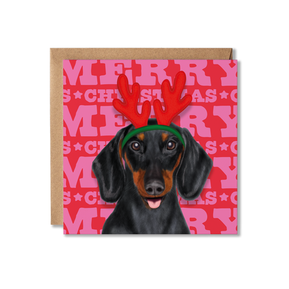 A Sausage dog Dachshund in a red reindeer headband and Merry Christmas background