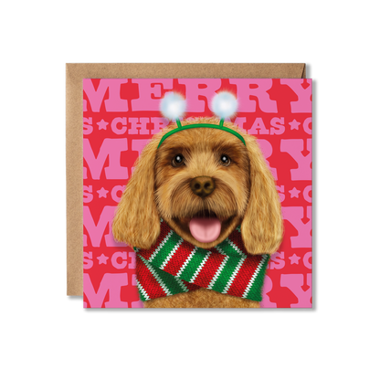 A tan cockerpoo dog in a fluffy snowball headband and red and green knitted scarf with a Merry Christmas background