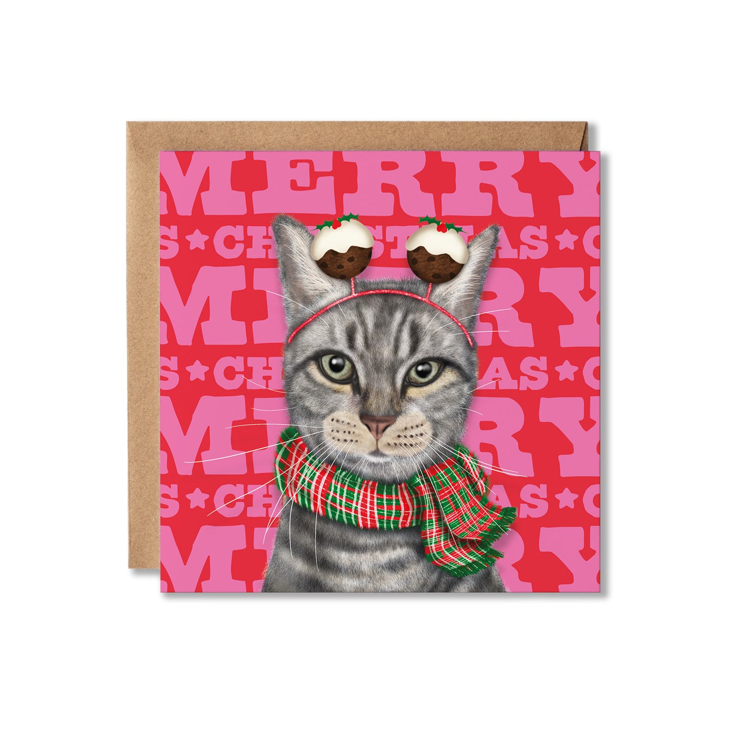 A square Christmas greeting card featuring an illustrated gray tabby cat wearing a red plaid scarf and Christmas pudding headband, set against a pink patterned background with the word 'MERRY' repeated. A kraft paper envelope is placed behind the card on a white background.