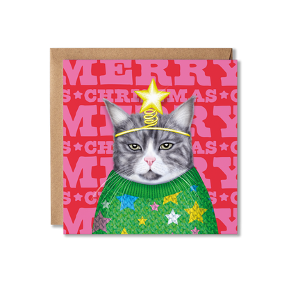 A grey and white cat wearing a green knitted jumper with stars on and a star headband with a colourful Merry Christmas background