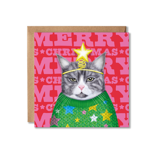 A grey and white cat wearing a green knitted jumper with stars on and a star headband with a colourful Merry Christmas background
